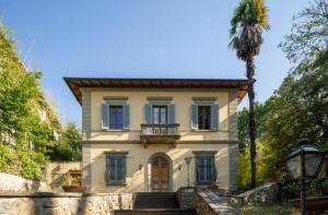 una casa con una palmera delante de ella en Villa Lia - Apartment in Villa with private garden and Pool en Florence