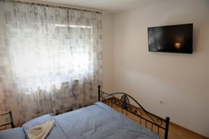 a bedroom with a bed and a television on the wall at Centar in Bijeljina