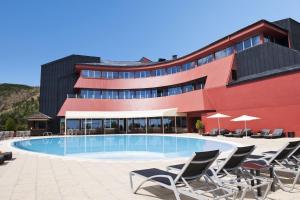um hotel com piscina em frente a um edifcio em Luna Hotel dos Carqueijais - Serra da Estrela na Covilh