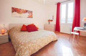 フィレンツェにあるApartments Florence - Battilana Terraceのベッドルーム1室(赤いカーテン付きのベッド1台、デスク付)