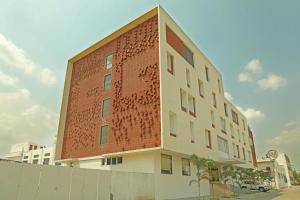 a building with a brick wall with writing on it at GG HOTELS in Tiruppūr