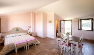 1 dormitorio con cama, mesa y escritorio en Country House Poggio Fiorito, en Asís