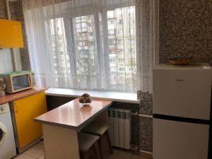 kuchnia z małym stołem przed oknem w obiekcie Kyiv daily rent Apartments on Bogdana Gavrilishina 10 w Kijowie