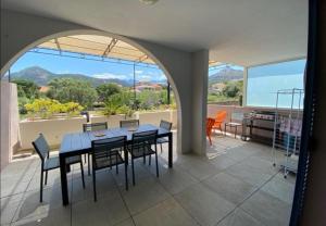 a dining room with a table and chairs and a large window at Repos à l'ile rousse in LʼÎle-Rousse