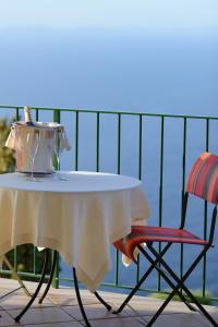 a table with a tea pot on it next to two chairs at Hotel Caesar Augustus in Anacapri