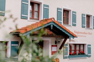 a building with a porch with flowers on it at Hotel Vogtareuther-Hof in Vogtareuth