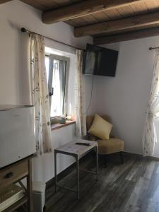 ein Wohnzimmer mit einem Tisch, einer Couch und einem Fernseher in der Unterkunft The Mousehouse in Áno Rínglia