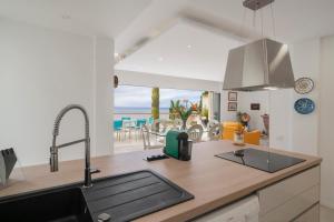 Una cocina con fregadero y vista al mar. en Villa Beach Club, en Santa Cruz