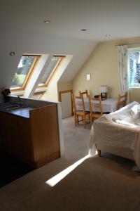 a bedroom with a bed and a dining room with windows at Cherry Trees in Stowmarket