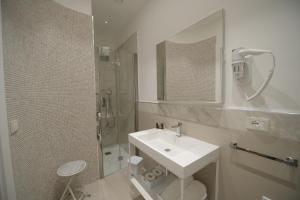 een witte badkamer met een wastafel en een douche bij "Corte Mopps" città della ceramica Grottaglie - SPA Elysium in Grottaglie
