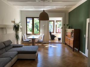 ein Wohnzimmer mit Sofa, Tisch und Stühlen in der Unterkunft Ferienwohnung an der grünen Clara in Erfurt