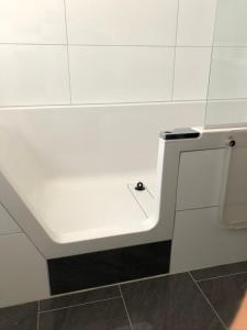 eine weiße Bank in einer weißen Kachelwand in der Unterkunft Ferienwohnung an der grünen Clara in Erfurt + 10 Fotos