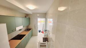 duża łazienka z zielonymi szafkami i umywalką w obiekcie Amazing ocean view apartment w Corralejo