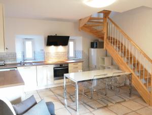 eine Küche mit einem Esstisch und einer Treppe in der Unterkunft LES 3 HIRONDELLES in Pont-Saint-Esprit