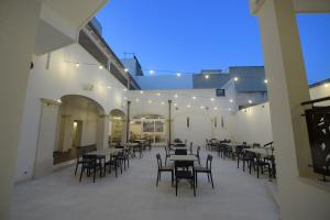an empty patio with tables and chairs at night at B&B "Corte Mopps" Grottaglie città della ceramica - SPA Elysium in Grottaglie