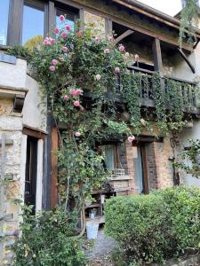 un bâtiment avec des fleurs sur son côté dans l'établissement Gîte De Chevreuse, à Chevreuse