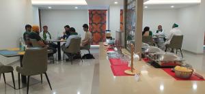 a group of people sitting at tables in a room at GG HOTELS in Tiruppūr