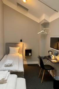 Habitación de hotel con cama y escritorio en Unique Hotel Jungfrugatan, en Estocolmo