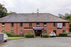 a brick building with cars parked in front of it at Plaza Hotel, Chorley, Sure Collection By BW in Chorley