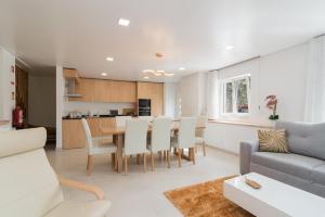 a living room and kitchen with a table and chairs at Casas Madalena in Seia