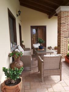 a patio with wicker chairs and tables with plants at Su Sattisceddu in Uras