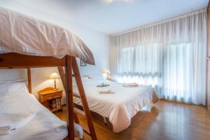 a bedroom with two bunk beds and a window at Il Ruscello Apartment with Terrace and View of the Alps in Tarvisio