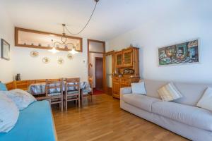 a living room with a couch and a dining room at Il Ruscello Apartment with Terrace and View of the Alps in Tarvisio