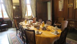 una sala da pranzo con un lungo tavolo e sedie di Château de Vitry-la-Ville a Vitry-la-Ville