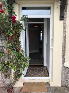 een open deur naar een huis met rozen bij Rose Cottage: Delightful 4 bedroom detached home in Portrush