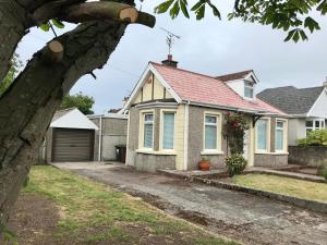 een huis met een rood dak bij Rose Cottage: Delightful 4 bedroom detached home in Portrush