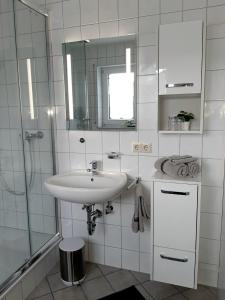 フォグツブルクにあるFerienwohnung "Am Blauwasser" mit Infrarotkabineの白いバスルーム(シンク、シャワー付)