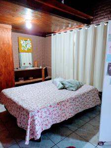 a bedroom with a bed with a table and a mirror at Espaço Mezanino in Mairiporã