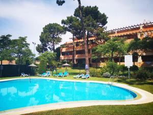 una grande piscina con sedie e un edificio di Pinogolf de Don Carlos a Marbella