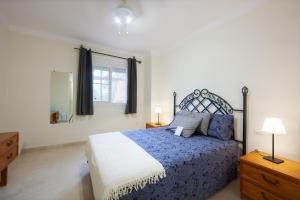 una camera con un letto blu e bianco e una finestra di Pinogolf de Don Carlos a Marbella
