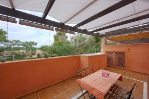 un patio con tavolo e sedie sul balcone. di Pinogolf de Don Carlos a Marbella