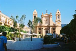 a building with a church with a clock tower at Casa Rosanna in Terrasini