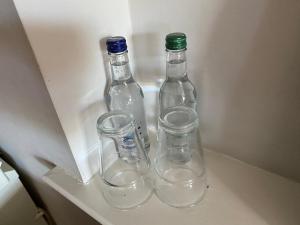 three glass bottles and cups sitting in a drawer at The Ship Inn in York