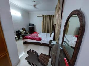 sypialnia z łóżkiem i lustrem w obiekcie Hotel Orash Lodge w mieście Nāluchhi