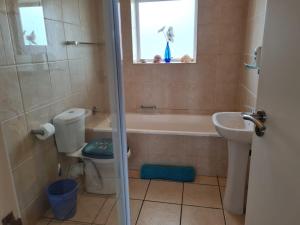 a bathroom with a tub and a toilet and a sink at Point Village Accommodation - Estoril 26 in Mossel Bay