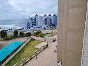 uma vista para a piscina a partir da varanda de um resort em Point Village Accommodation - Estoril 26 em Mossel Bay