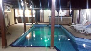 - une piscine avec 2 chaises dans l'établissement Pousada Requinte da Mantiqueira, à Piracaia