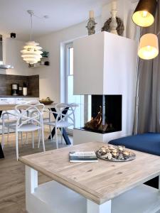 ein Wohnzimmer mit einem Tisch und einem Kamin in der Unterkunft Alte Fischfabrik in Putbus