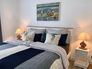 ein Schlafzimmer mit einem Bett mit blauer und weißer Bettwäsche und Lampen in der Unterkunft Alte Fischfabrik in Putbus