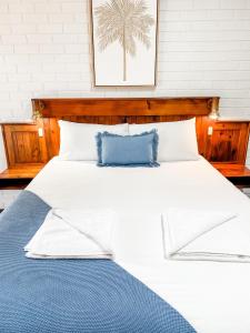 a bed with two pillows and a night stand at Pacific Sun Bargara in Bargara