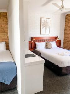 a bedroom with a bed, a desk and a window at Pacific Sun Bargara in Bargara