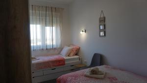 um pequeno quarto com 2 camas e um espelho em Apartman Luka em Pula