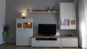 uma sala de estar com televisão e armários brancos em Apartman Luka em Pula