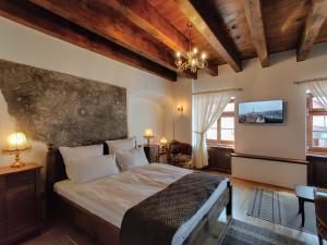 a bedroom with a large bed and a tv at La Teo Pensiune si Pivnita in Sighişoara