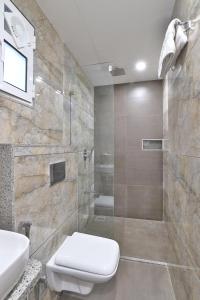 a bathroom with a shower with a toilet and a sink at 7 Orbit Hotel, Surat in Surat