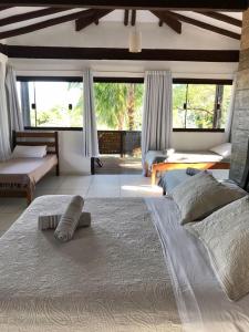 a bedroom with a large bed and a large window at Moana Ilhabela in Ilhabela